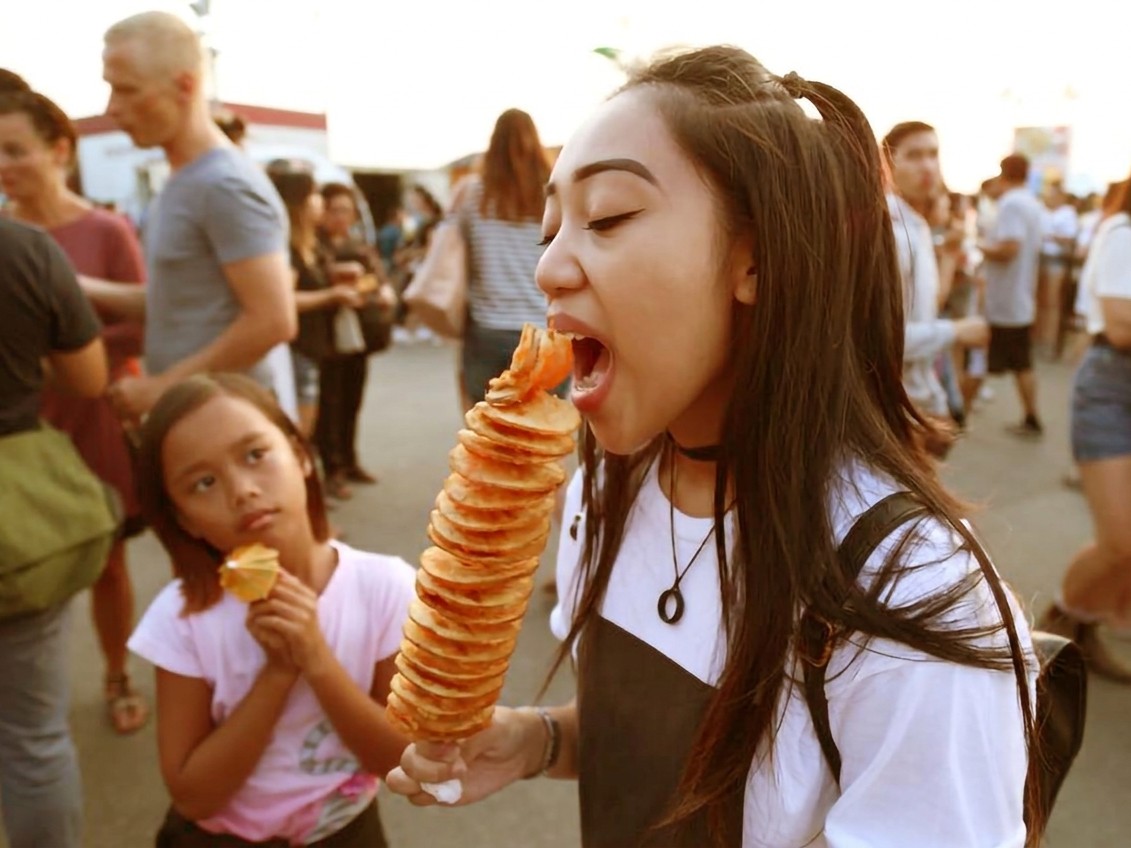 A festival-goer enjoying street food at a trader pitch
